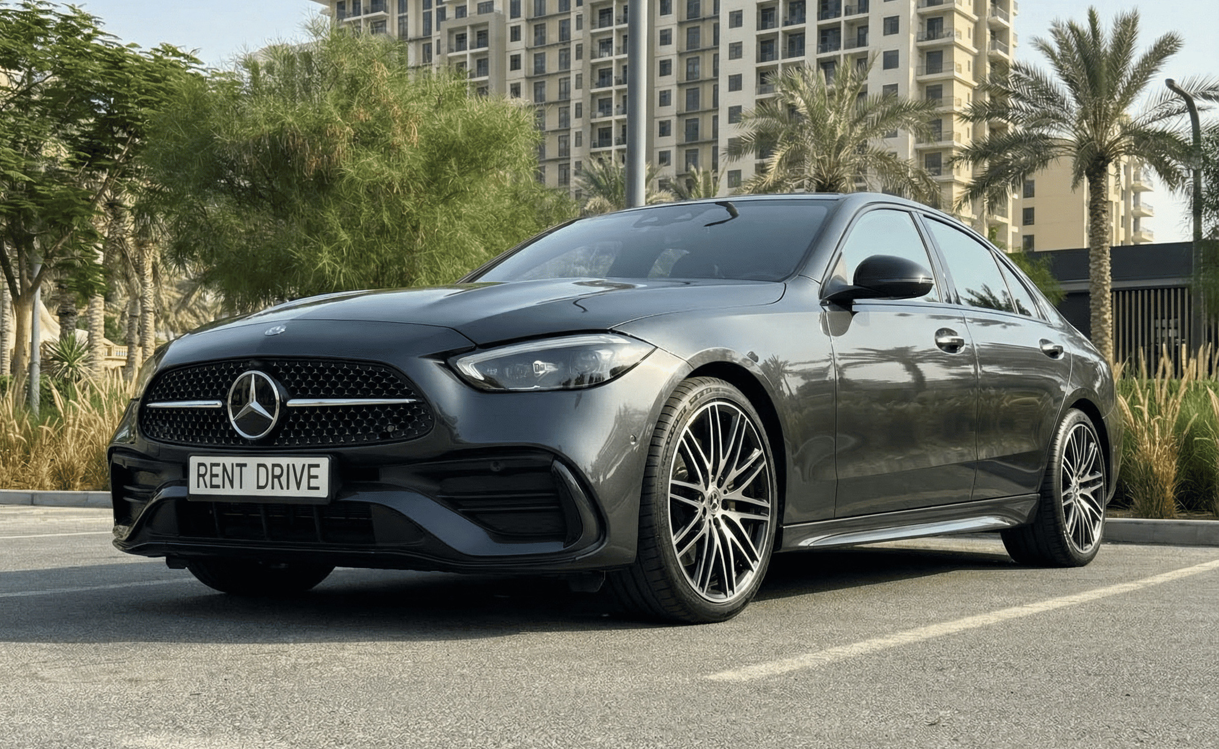 alt - سيارة Mercedes-Benz C-Class مستأجرة ومتوقفة في دبي خلال طقس صيفي حار